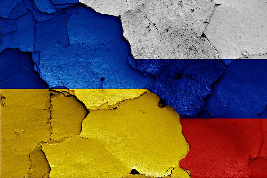 flags of Ukraine and Russia painted on cracked wall